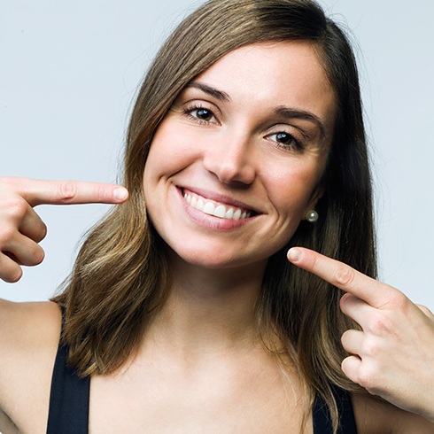 Woman pointing to her smile