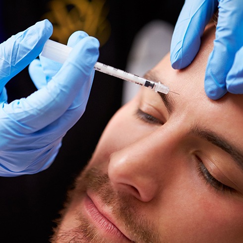 Man receiving an injection in his forehead