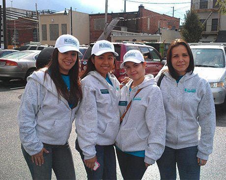 Four dental team members wearing matching sweatshirts at community event