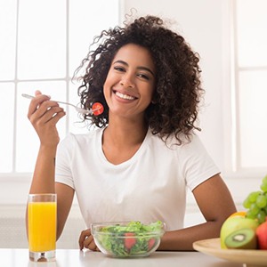 Smiling woman eating a salad
