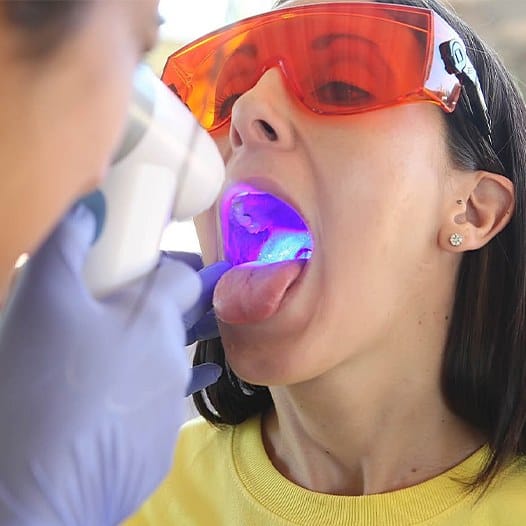 Woman receiving an oral cancer screening from her dentist