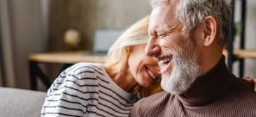 Senior man and woman laughing together at home