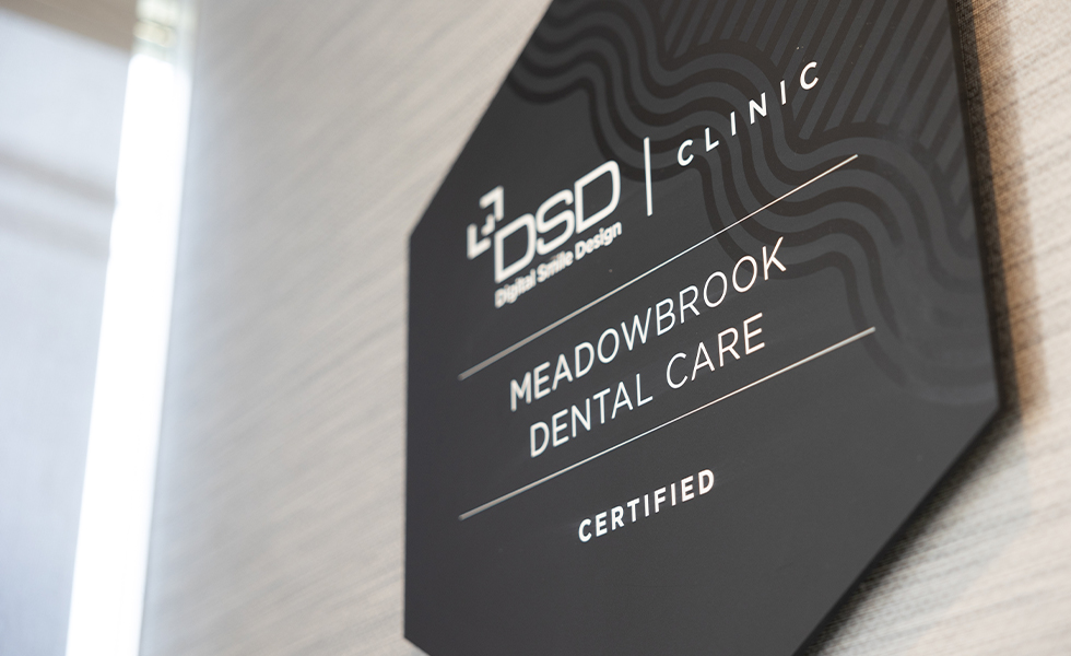 Sign on wall reading Digital Smile Design Clinic Certified Meadowbrook Dental Care