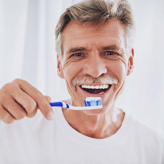 Smiling senior man holding a toothbrush