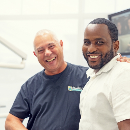 man smiling with his dentist in Mineola dental office