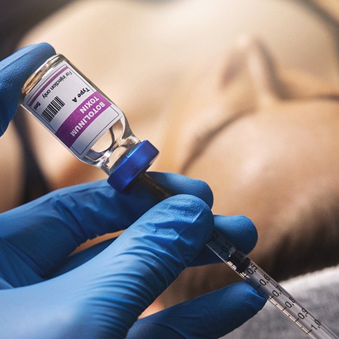 a dentist extracting BOTOX from a bottle 
