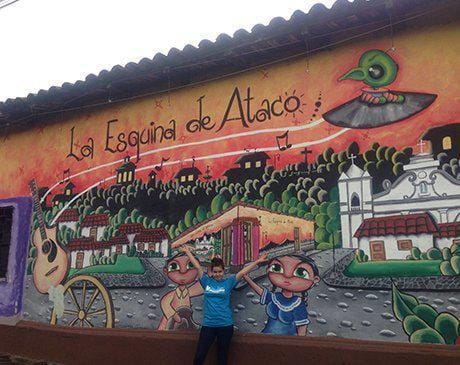 Dental team member posing in front of a mural