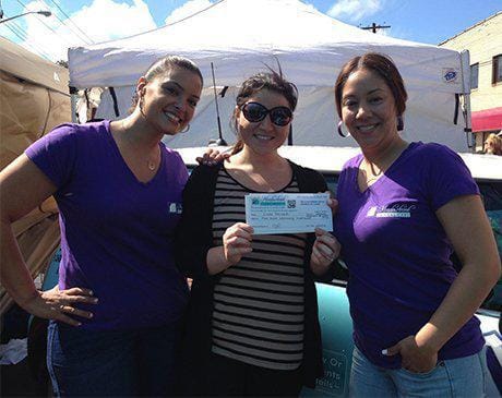 Two team members and dental patient at community event