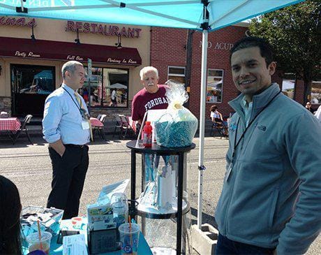 Dentists talking to dental patient at community event