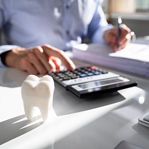 Person typing on calculator on desk