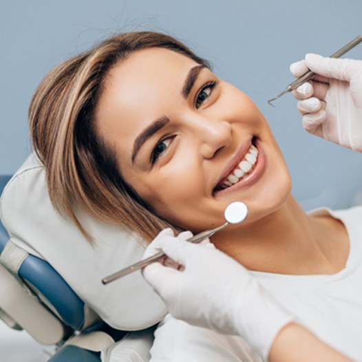 Woman smiling during dental checkup and teeth cleaning in Mineola