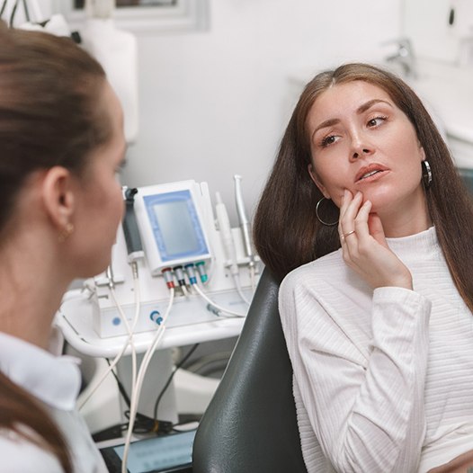 Man in patterned shirt with tooth pain; dental emergency in Mineola, NY