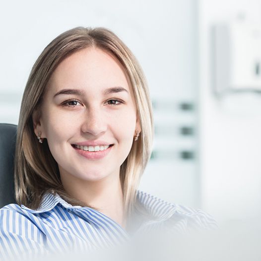 Blonde female dental patient sitting and smiling