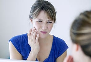 Woman with toothache holding cheek