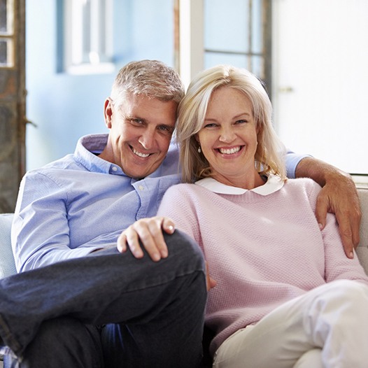 Senior man with his arm around senior woman on couch