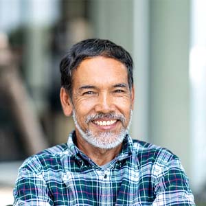 Smiling older man in blue plaid shirt