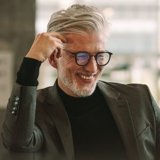 Older man in suit smiling and looking down