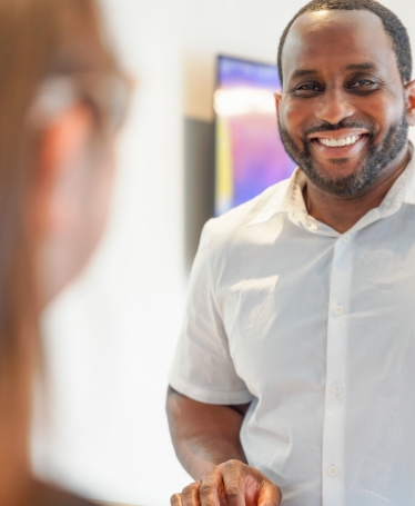 Man smiling at dental office receptionist