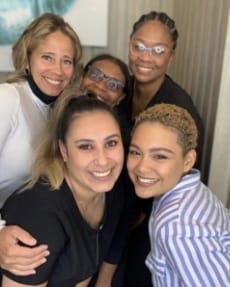 Five dental team member smiling together in dental treatment room