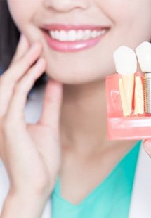 a person holding model of dental implants near Garden City