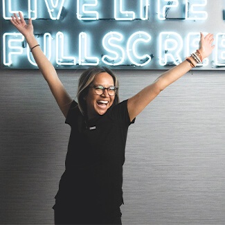 Dental Hygienist Ashley cheering with arms raised