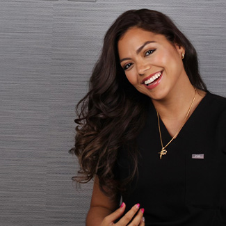 Dental Hygienist Leydi smiling and tossing her hair over her shoulder