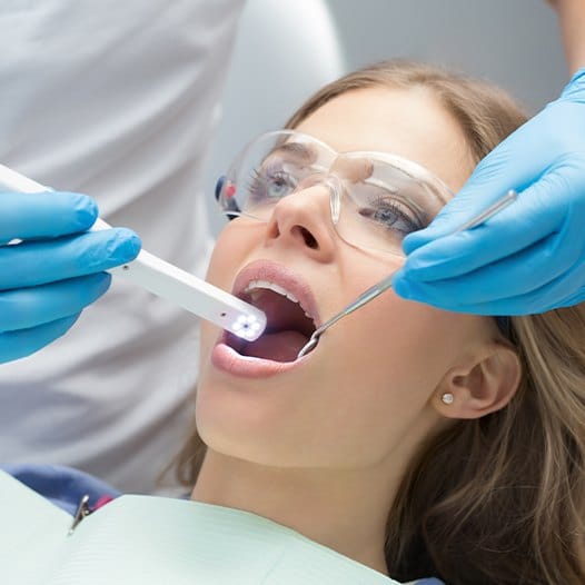 Dentist using intraoral camera to capture images of a patient's smile
