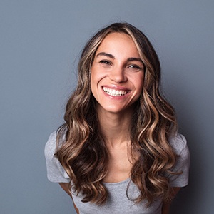young woman smiling after getting veneers in Mineola 