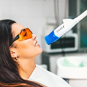 Woman receiving teeth whitening in dental office