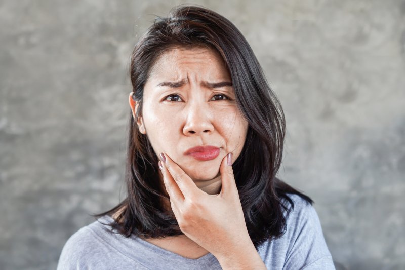 Woman with facial swelling rubbing her chin