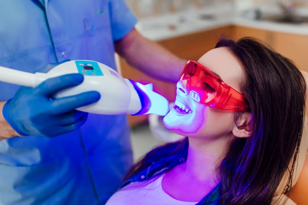 A woman getting professional teeth whitening from her dentist